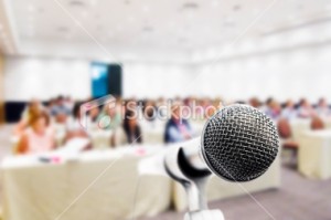 stock-photo-15793850-close-up-microphone-conference-attendees-in-background